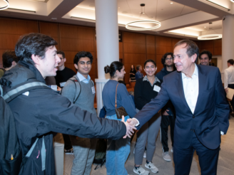 John Paulson (BS ’78) John Paulson (BS ’78) shakes hands with a student